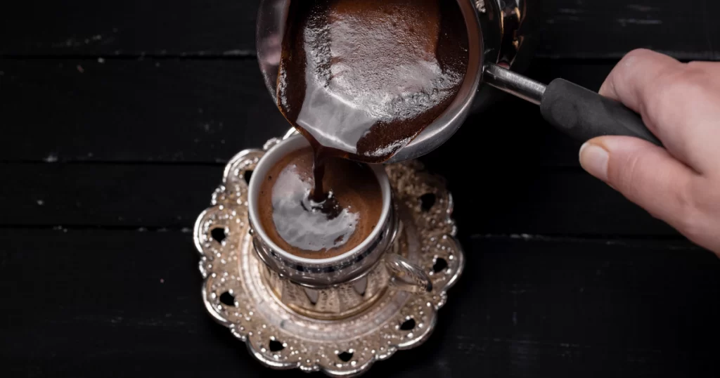 Pouring Turkish coffee in a beautiful cup