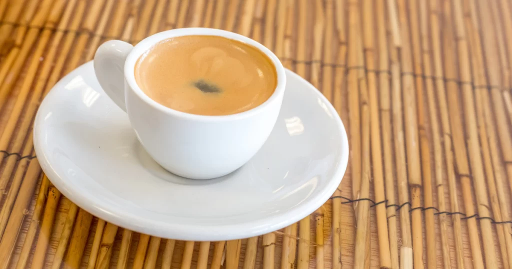 Cuban coffee with milk in a small white cup