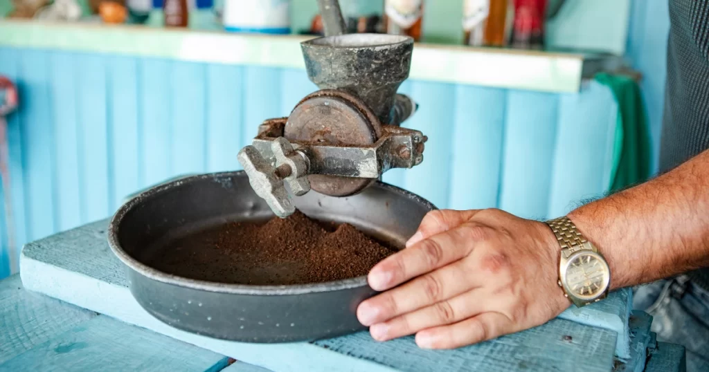 Man grinding Cuban coffee in the old fashioned way